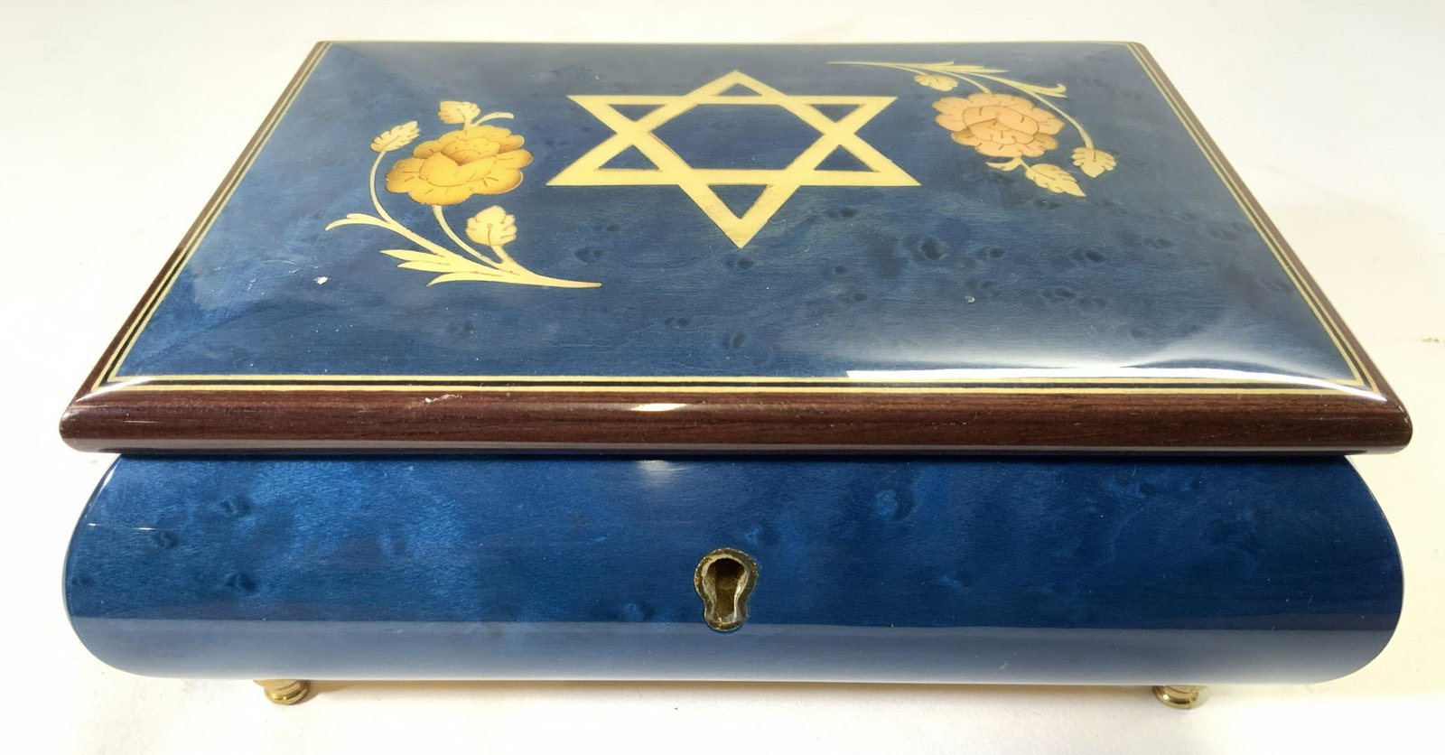GIGLIO ASLA Inlaid Judaica Music Jewelry Box ITALY: Tag reads GIGLIO ASLA MADE IN ITALY. Box is inlaid wood. Piece has Star of David, floral & Leaf detail. Piece has tones of blue, brown & cream. Piece has gold toned brass feet. Under side has music wi