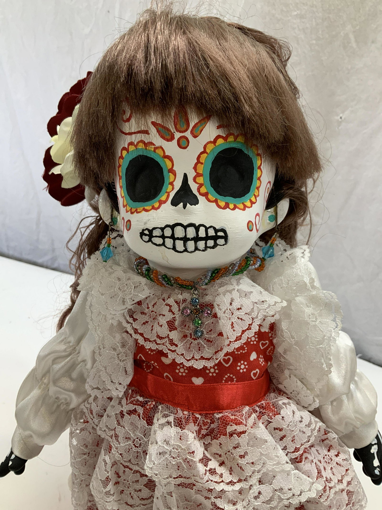 PRECIOUS MOMENTS Hand Painted Skeleton Doll, stand: Signed Precious Moments Skeleton doll , c. 1992 with artistâ€™s name Samuel Butcher. Hand painted face and hands, a resinous material. Doll is wearing a red and white dress, has an attached brown