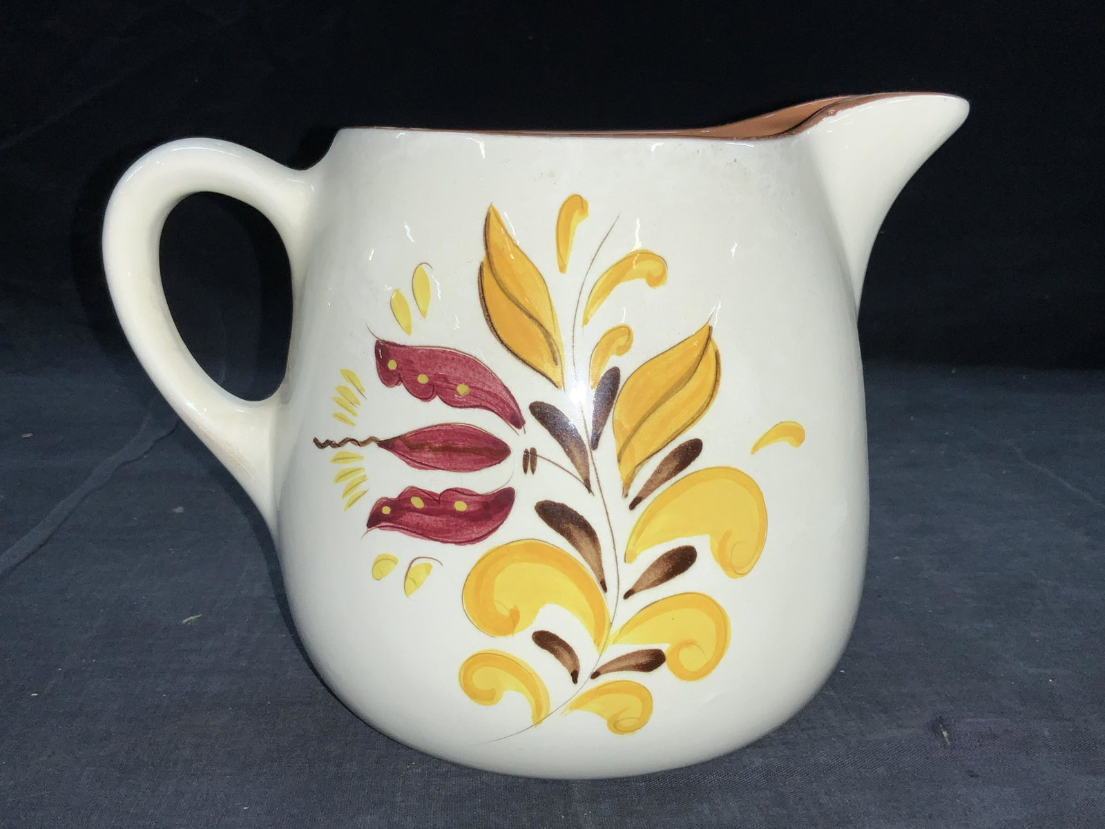 Vintage Hand Painted STANGL Pottery Pitcher: Vintage Stangl marked pottery pitcher. Hand Painted with yellow and magenta flowers on sides and terracotta toned interior. Approximately 6.5 inches tall and 9 inches wide. Minor wearing due to age an