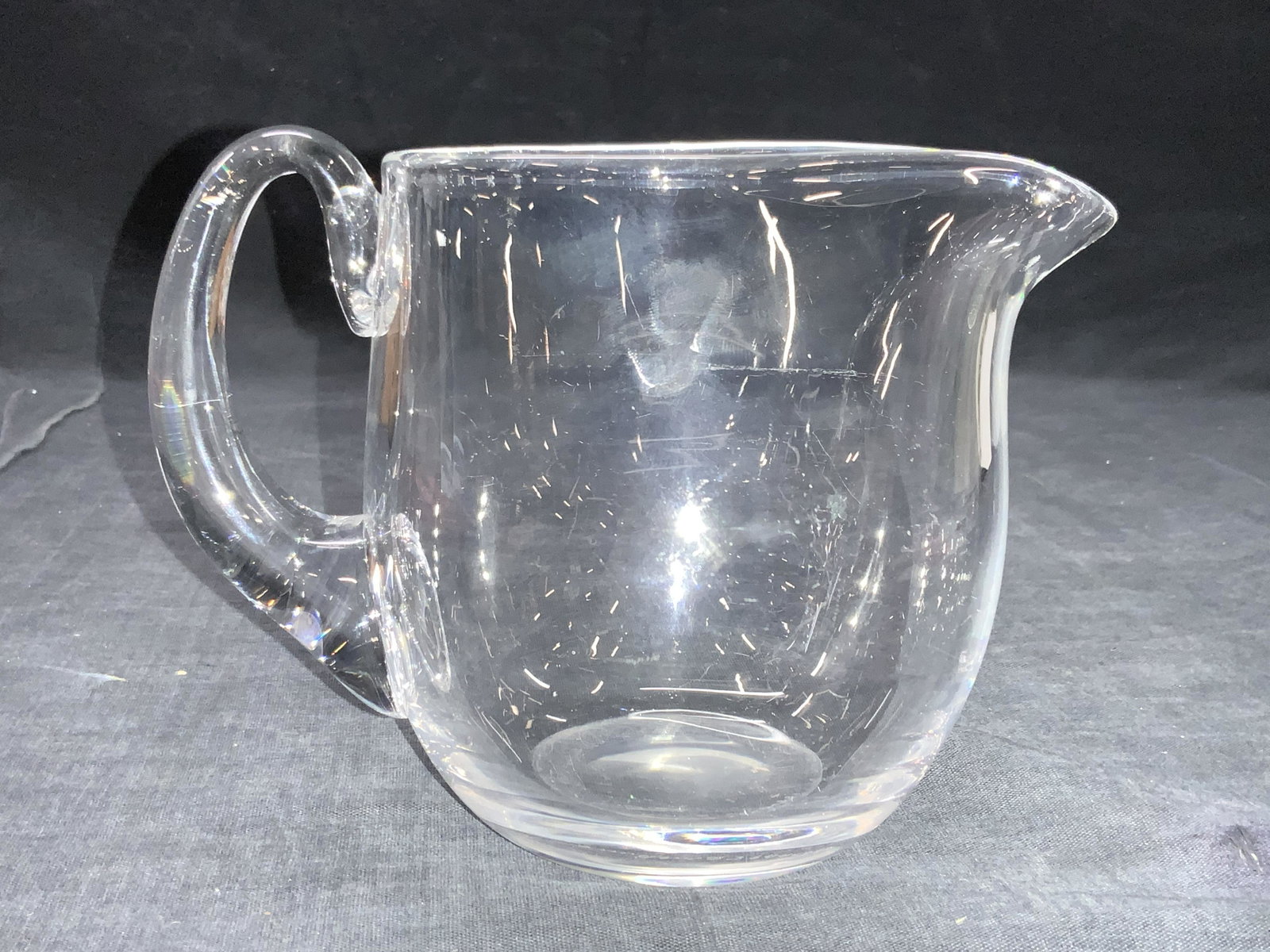 ORREFORS Signed Clear Crystal Pitcher: Signed on underside Orrefors 644-881 Clear crystal pitcher with lipped rim and back handle Approximately 4.75 inches all and 5 inch diameter. Moderate wearing to underside Orrefors crystal pitcher, Or