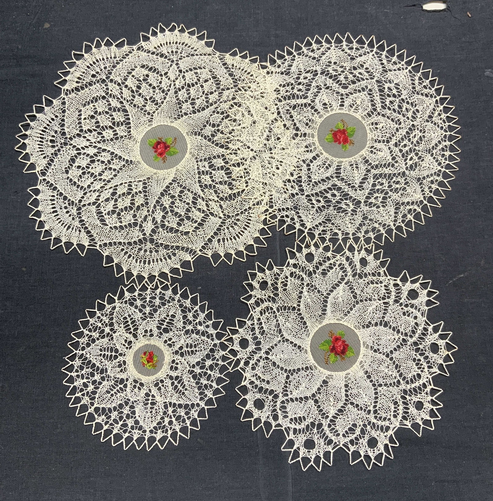 Lot 16 Vintage Floral Lace Doilies: Set of 12 vintage white lace doilies with floral motif. in a box. Measure approx. 5.5 inches diameter each. All pieces have blemishes observed. Set of 4 vintage white lace doilies with needlepoint flo