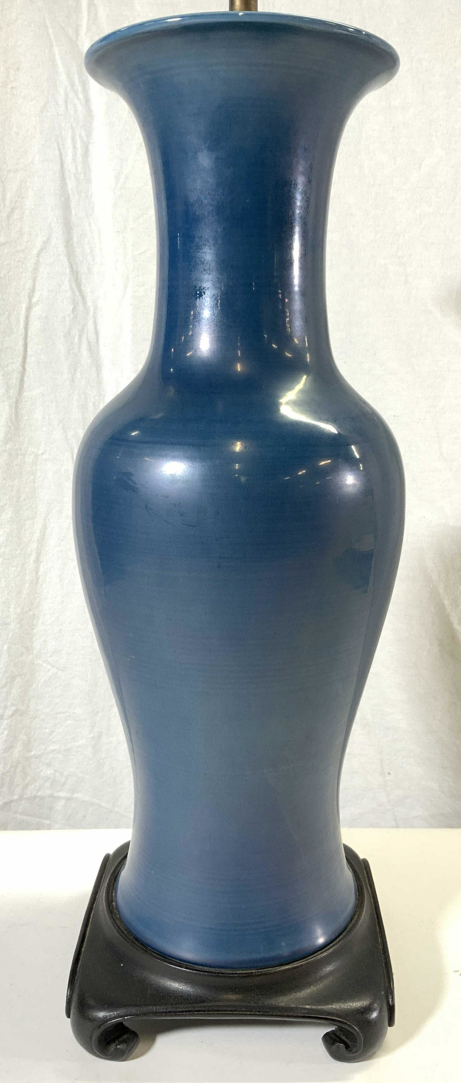 Porcelain Table Lamp W Wooden Base Blue: Lamp is blue toned and porcelain. Piece has black toned carved wooden base. Lamp includes harp & finial. Piece measures approx 33 inches tall 6 inches wide. Lamp, table lamp, porcelain table lamp, blu