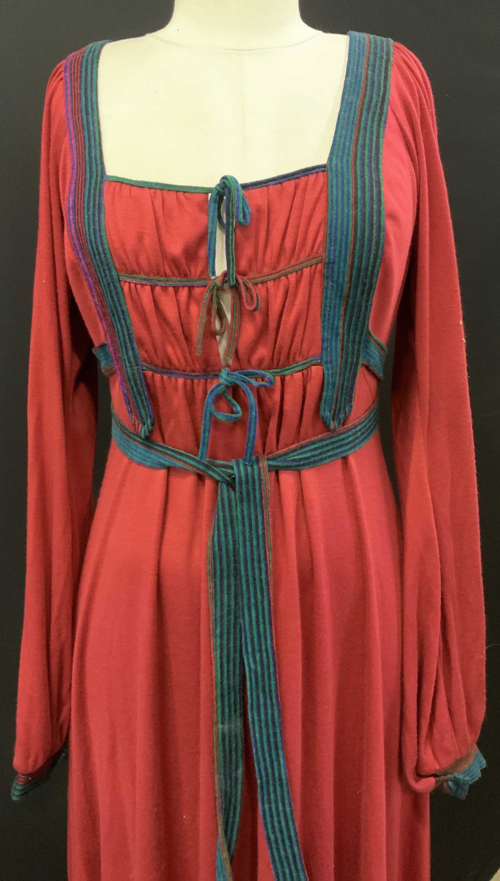 Handmade Bavarian Dirndle Farm Dress: handmade Bavaiaran Dirndle ( also spelled Durdle) dress, Waist 34 in. , length 55.5 in. Brick red with striped trim and cuffs, long tie belt attached to dress. Backside zipper. Possibly a nylon blend 