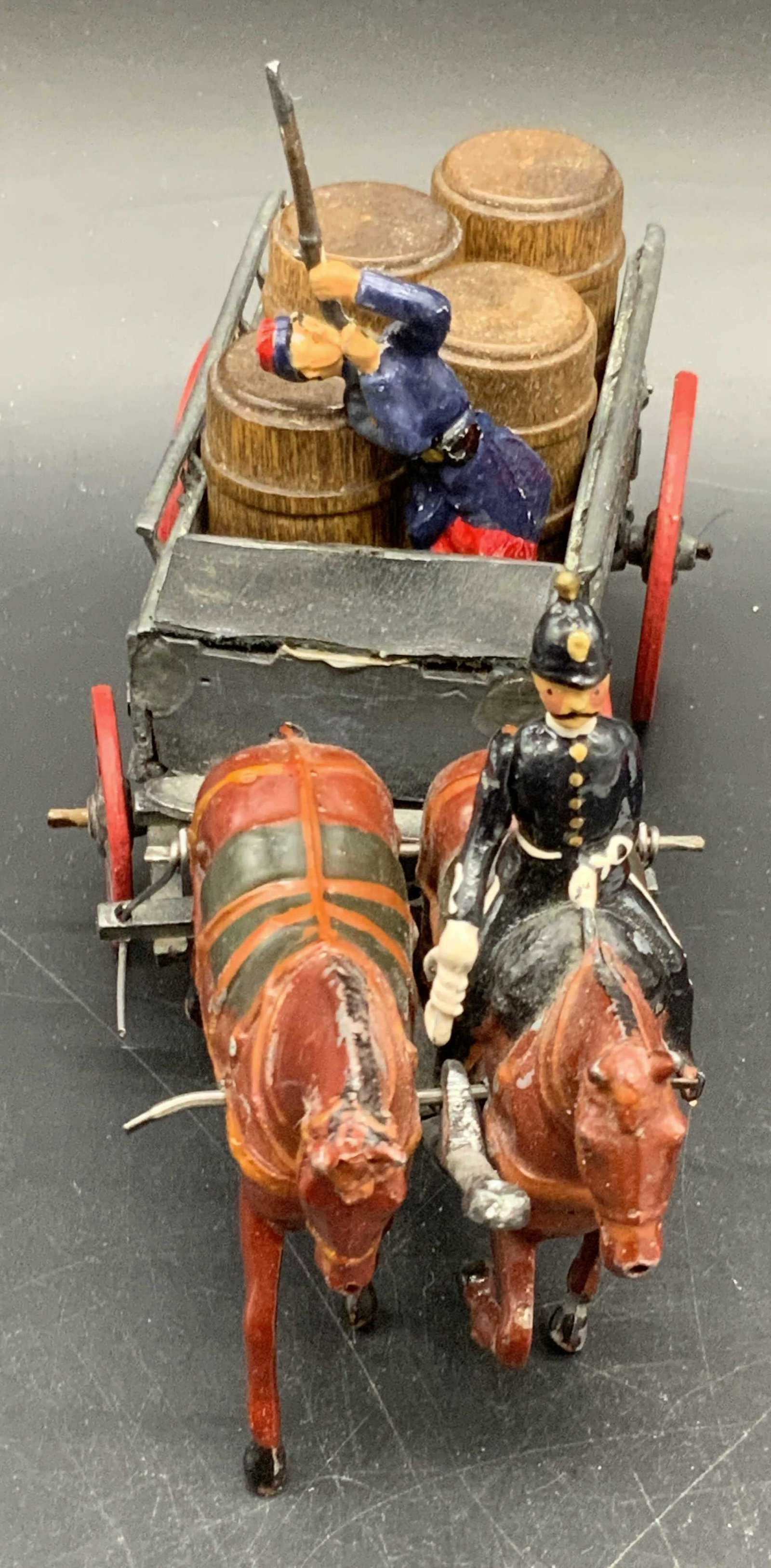 Vintage Hand Painted Metal Soldier Toys & More: This lot of vintage metal toys includes: one soldier sitting atop horses & pulling a carriage, four wooden barrels, and one soldier holding a gun. The barrels appear to be crafted from wood, the soldi