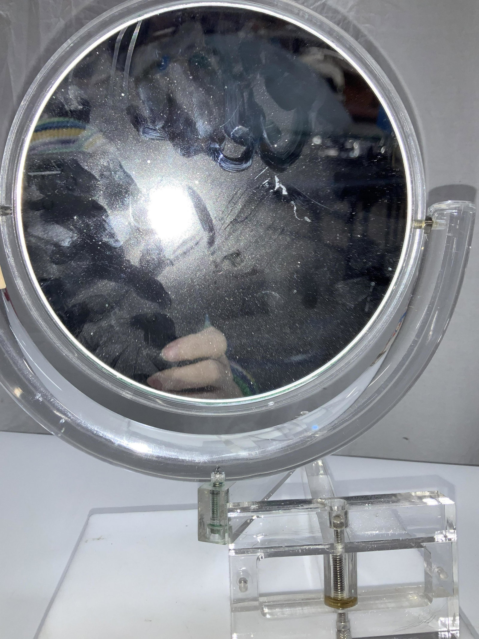 Acrylic Magnifying Swivel Wall Mirror: Long arm mirror that attaches to the wall and pivots at 3 points. Mirror rotates, one side app 15x, maybe 20x magnifier, the other side normal. mirror itself measures 8 in diameter. Arm length 14 in.