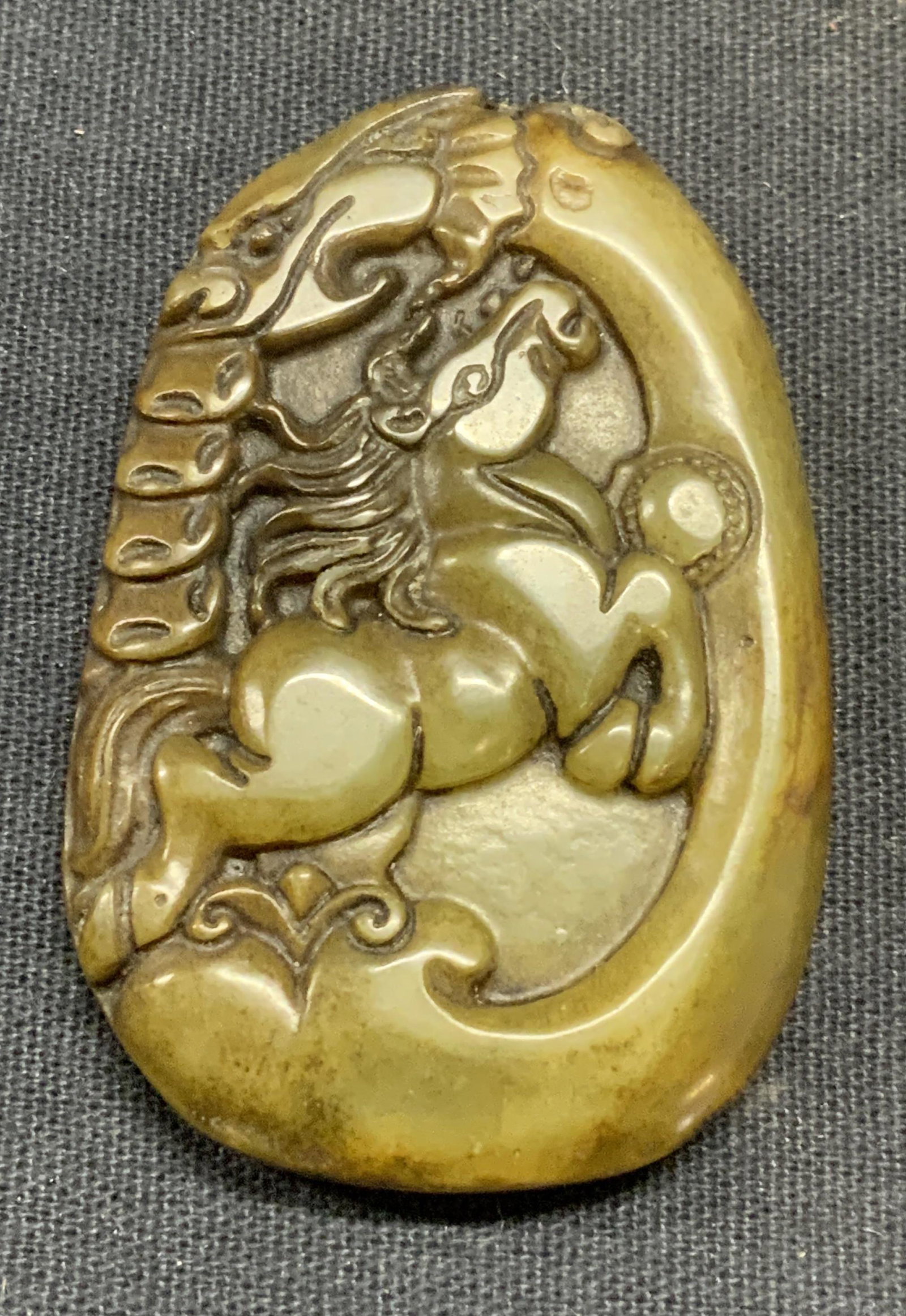 Carved Jadeite Gemstone Asian Horse Pendant: Carved jadeite gemstone pendant with Asian horse motif. Some surface wear consistent with exposure. Measures approx. 2 1 3/8 inches. Estate jewelry, fine jewelry, cocktail jewelry, fashion jewelry, ac