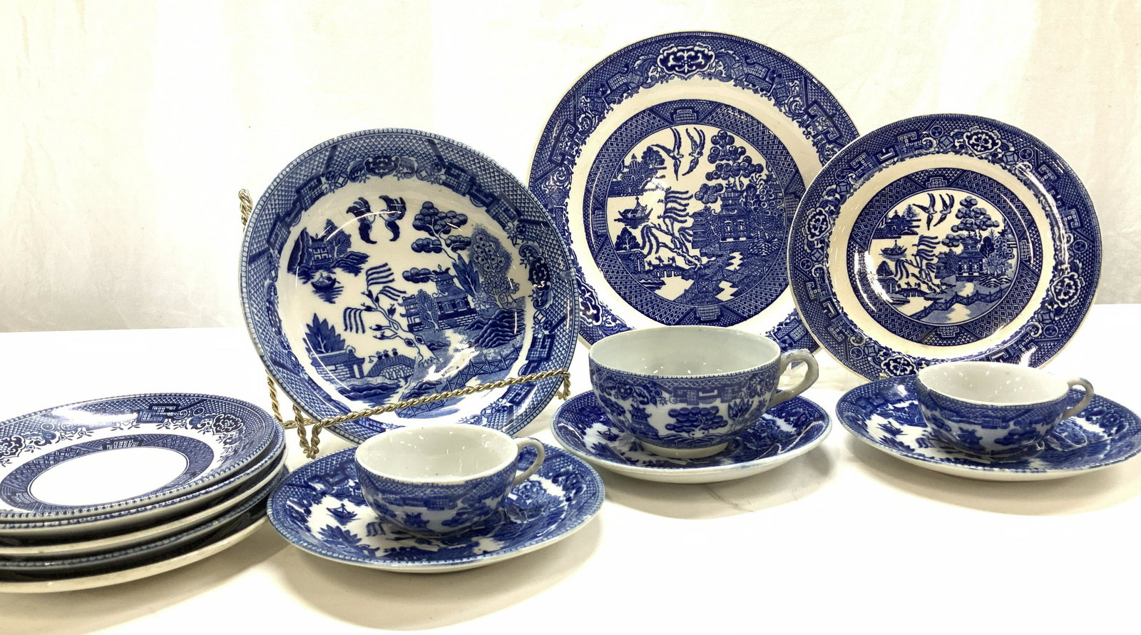 Set 14 Asian Blue Willow Porcelain Tableware: Porcelain Flow Blue Willow Asian Plates, demitasse cups, saucers, and bowl., Vintage, possibly early 20 the century Transferware blue and white pieces, same design but vary with quality of Transferwar