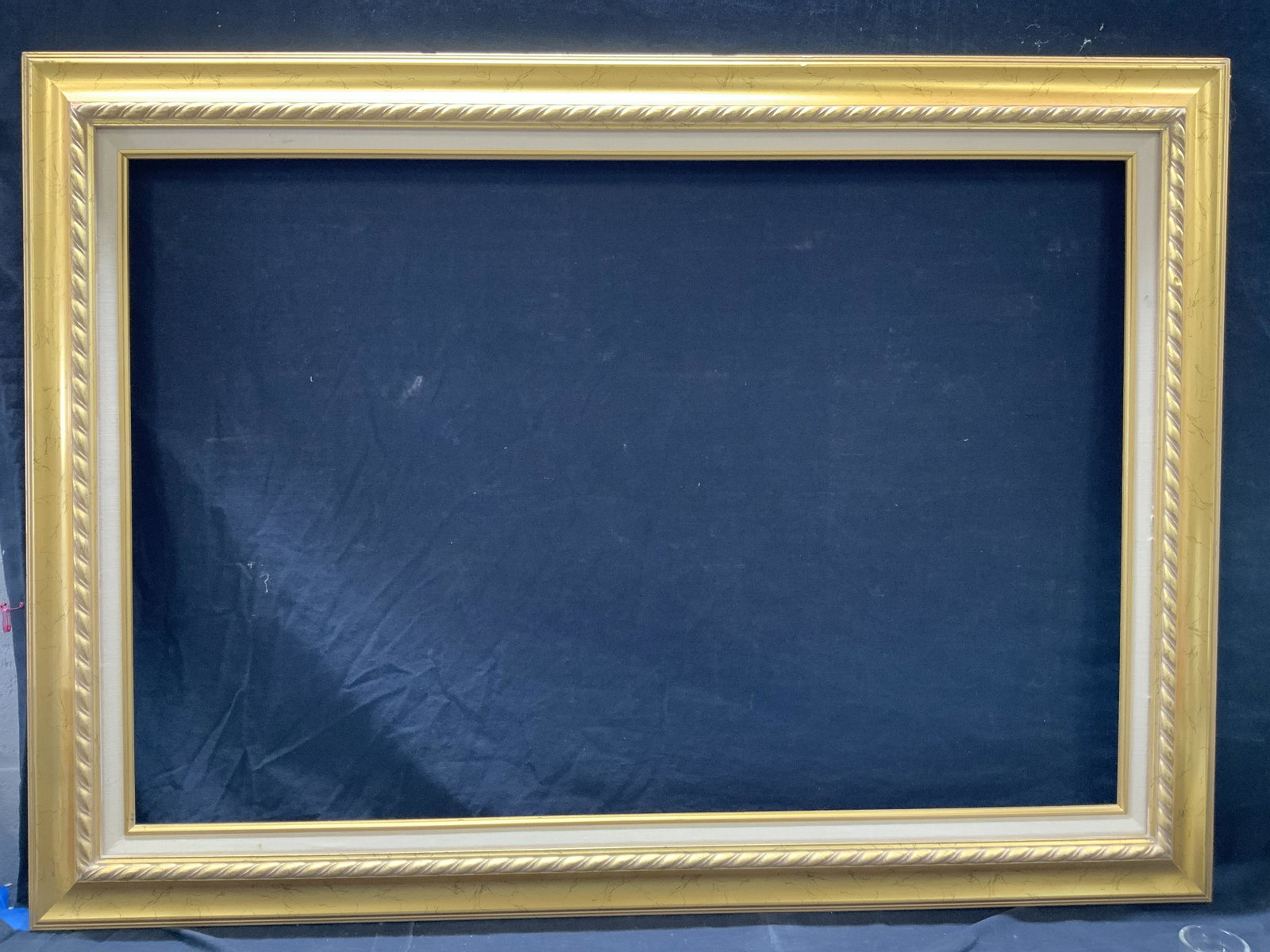 Mid Century Style 31 x 43 In Gilt Wood Frame: Mid century style wooden frame with gold leafing throughout. Carved braided accent rim and linen inner edge. Approximately 31 x 43 horizontally . Window measures 24 x 35.5 inches horizontally. Can be 
