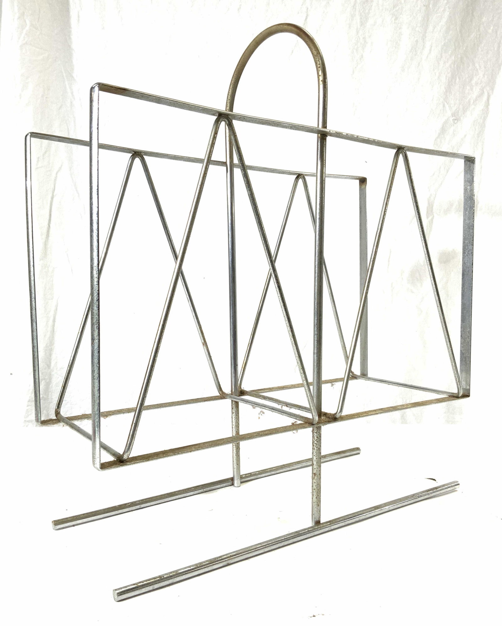 Mid Century Modern Metal Magazine Holder: Magazine holder is silver toned & metal. Piece is mid century modern. Magazine holder has arched handle. Measures approx 18 inches tall 16 inches wide 6 inches deep. Magazine rack, magazine holder, me