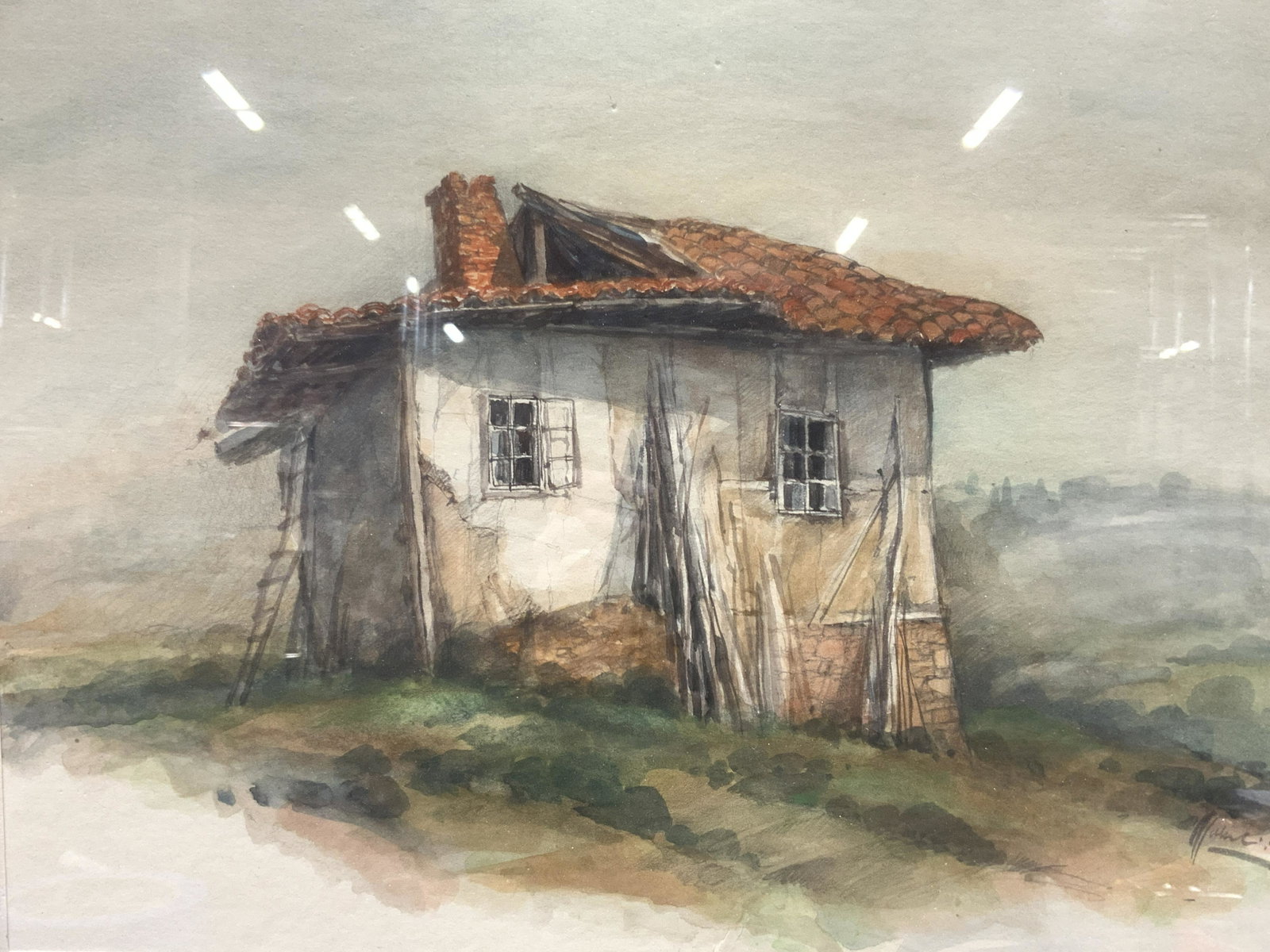 Signed Watercolor Shake House Painting: Signed on lower right corner, illegibly. Subject depicts an abandoned house with dilapidated red tile roof with cracked walls in a green field. Professionally framed in gold toned wooden frame with ru