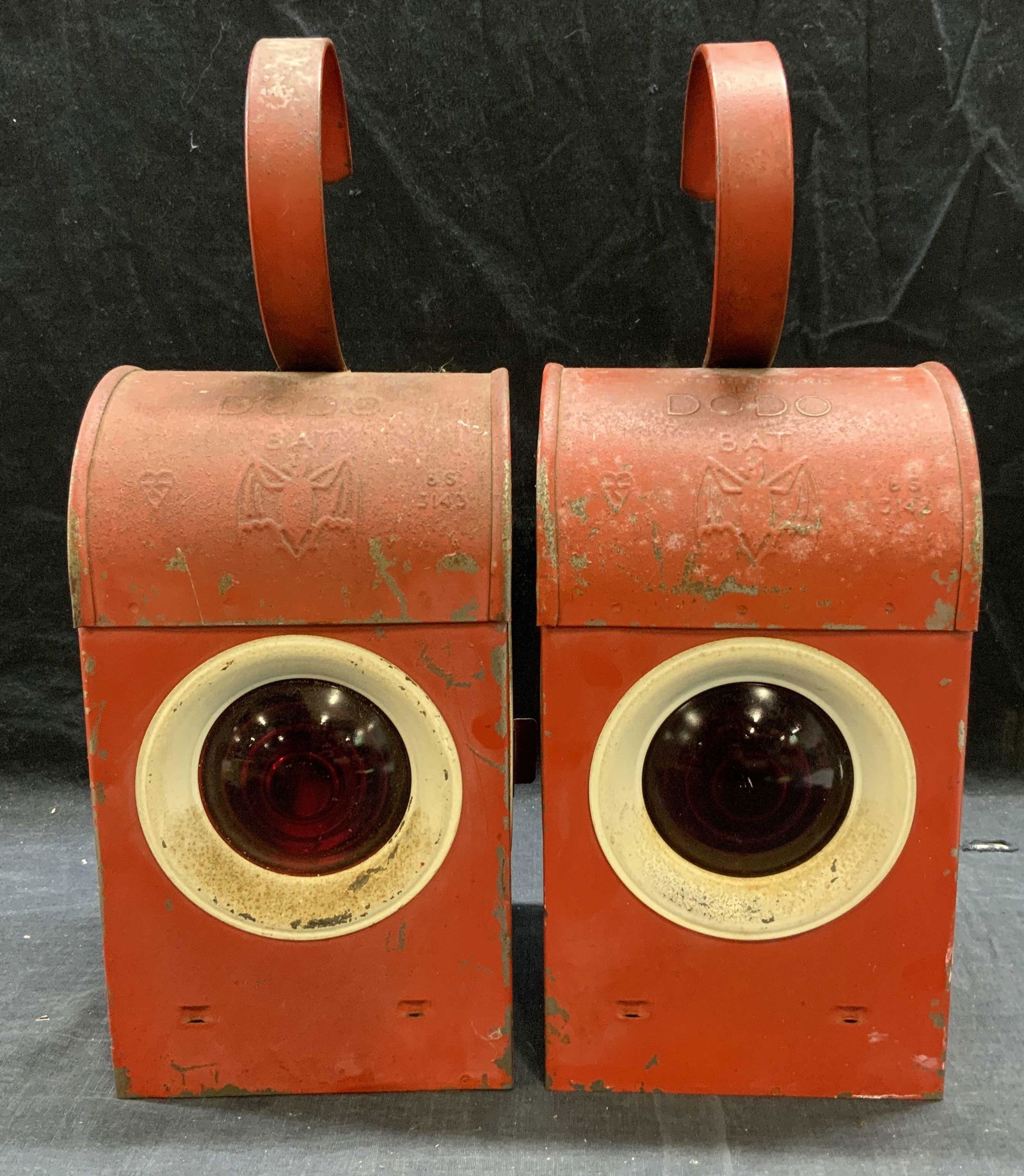 Pair DODO Bat Model Railroad Traffic Lanterns: Pair of vintage, possibly antique, Dodo ‘Bat’ model red railroad traffic lanterns. Enameled Metal and glass with kerosene lamp inserts. Trademarked on metal. Made in England. Manufactured first ha