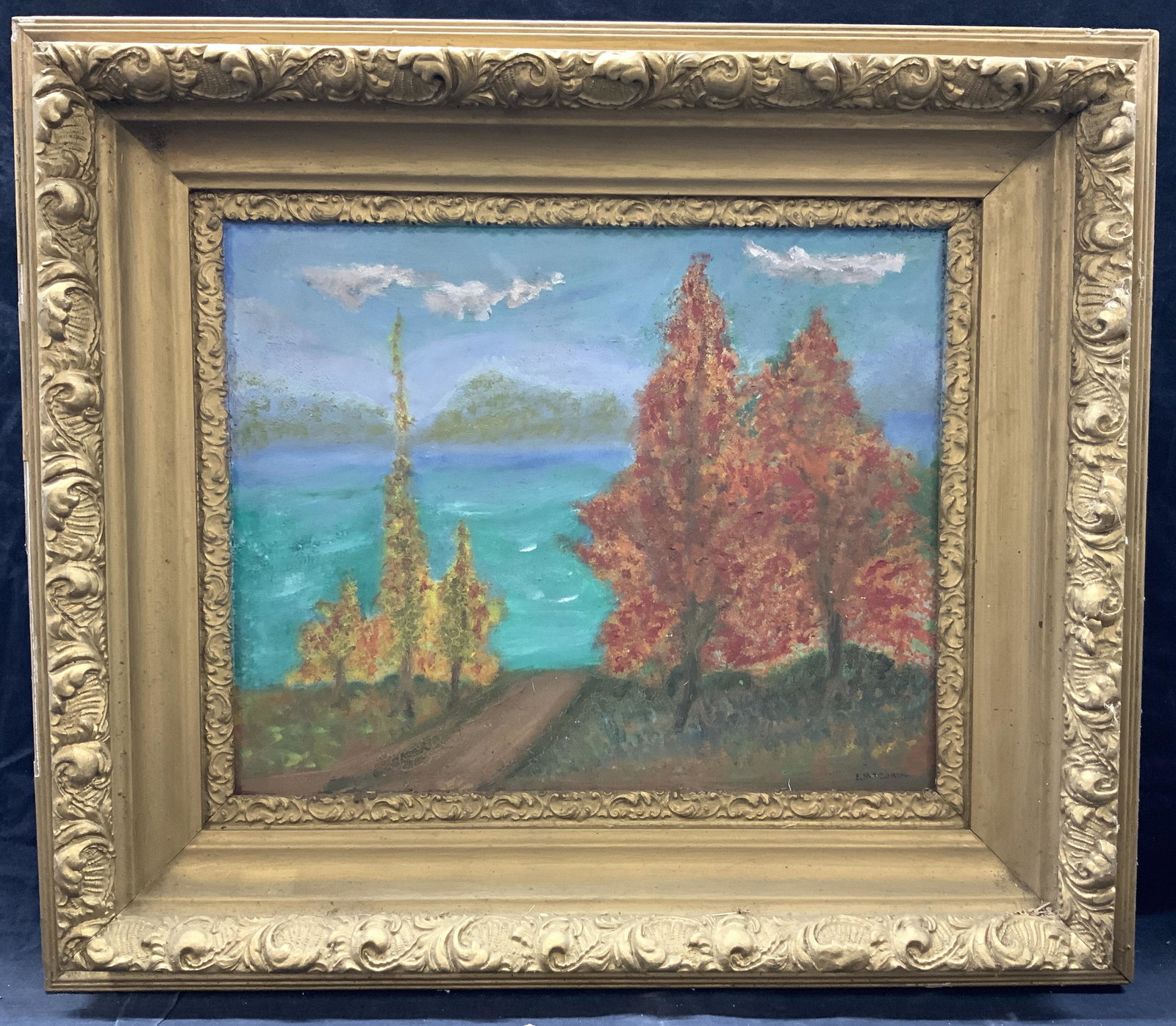 E.M.Cord Signed Vintage Landscape Oil Painting: Signed on lower right corner E.M.Cord Depicts trees within a blue and teal landscape Framed in gold painted wooden and plaster made frame with ornate scroll designs on outer and inner edges. Approxima