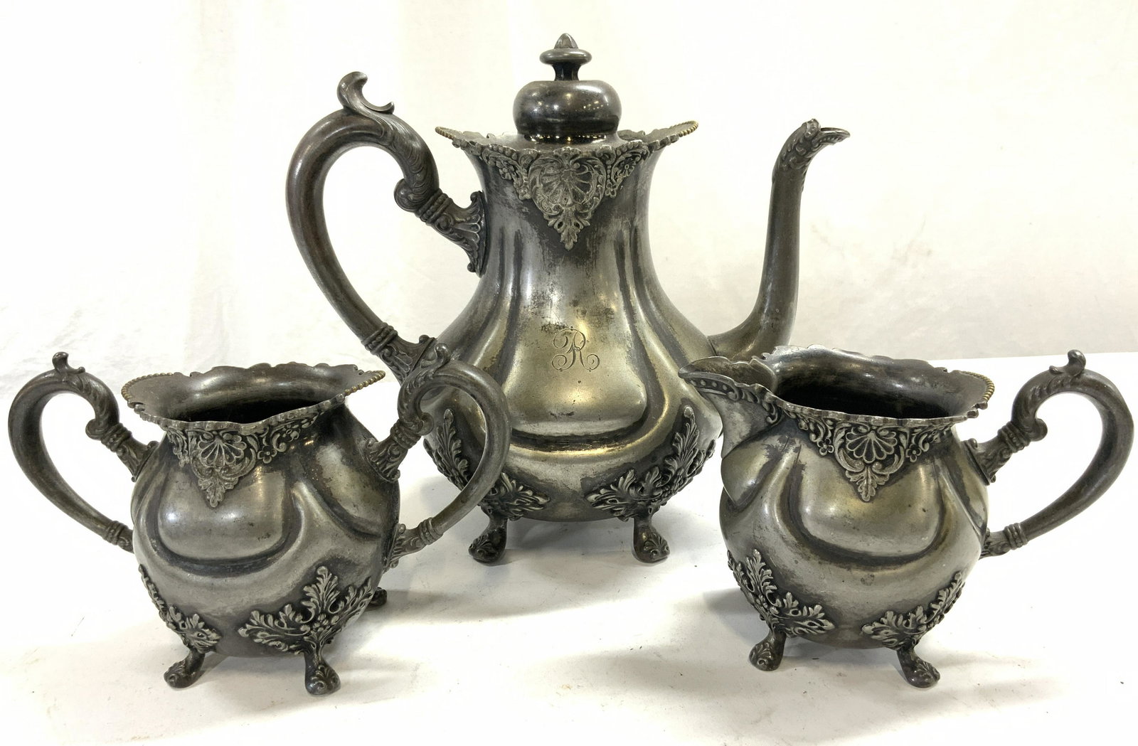 E.G. Webster & Son S Plate Cof Pot Creamer & Sugar: Underside of each piece has E.G. Webster & Son letter W inside a spiderweb trademark inscribed on underside. Each piece has scrolled leaf detail and 4 feet. Pieces all have R monogram. Coffee pot incl