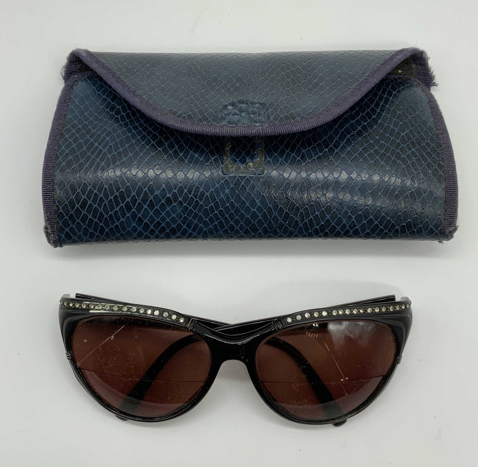 Nina RICCI Black Rhinestone Sunglasses: Nina RICCI rhinestone decorated black acrylic frame sunglasses with case. Measure approx. 5 x 5.5 x 2 inches. Designer label to arm. Surface wear consistent with exposure. Nina RICCI, Nina RICCI sungl