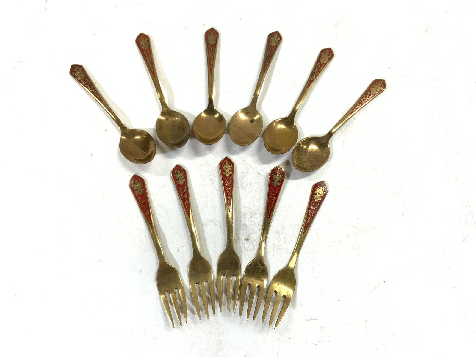 11 Brass & Red Enam Demitasse Spoons Hors D Forks: Some Undersides read THAILAND. Lot includes 6 demitasse spoons & 5 Hors Doeuvres forks. Each piece is brass with red enamel detailing. Each has depiction of Buddha on handles. Demitasse spoons measure