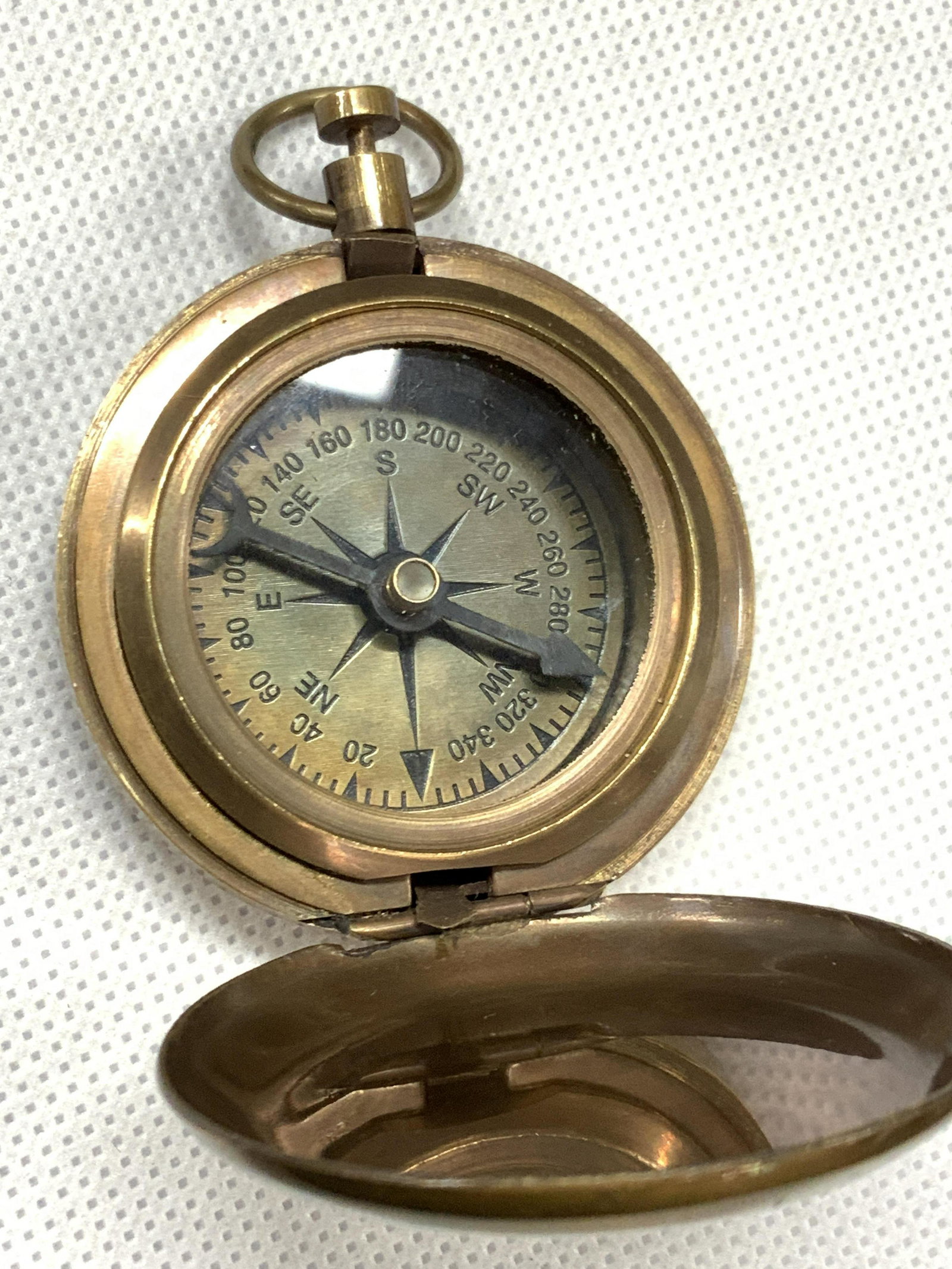 Rose London Maritime Brass Compass: Brass made compass with Rose London on front, along with an etched image of a sailing ship with an oversized anchor. Approximately 2.5 inches long and 2 inches wide. Moderate surface wear. Rose London