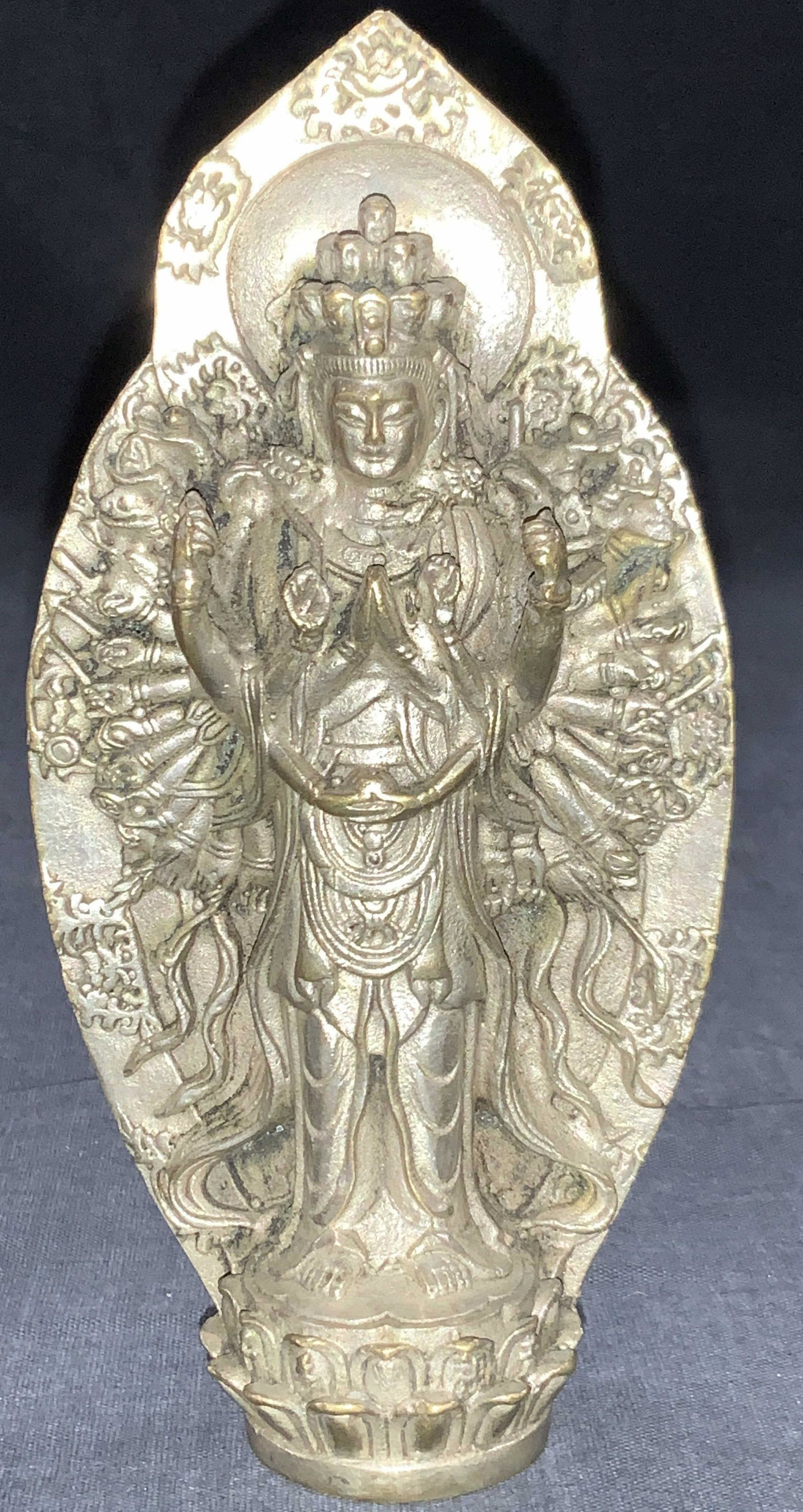 Silver Tnd 1000 Arms Goddess Guan Yin Figure: Silver toned sculpture of 1000 arms avalokiteshvara goddess Guan Yin. Depicting standing on a lotus base with 1000 arms behind her ,all holding religious symbols. Approximately 6.25 inches tall. Evide
