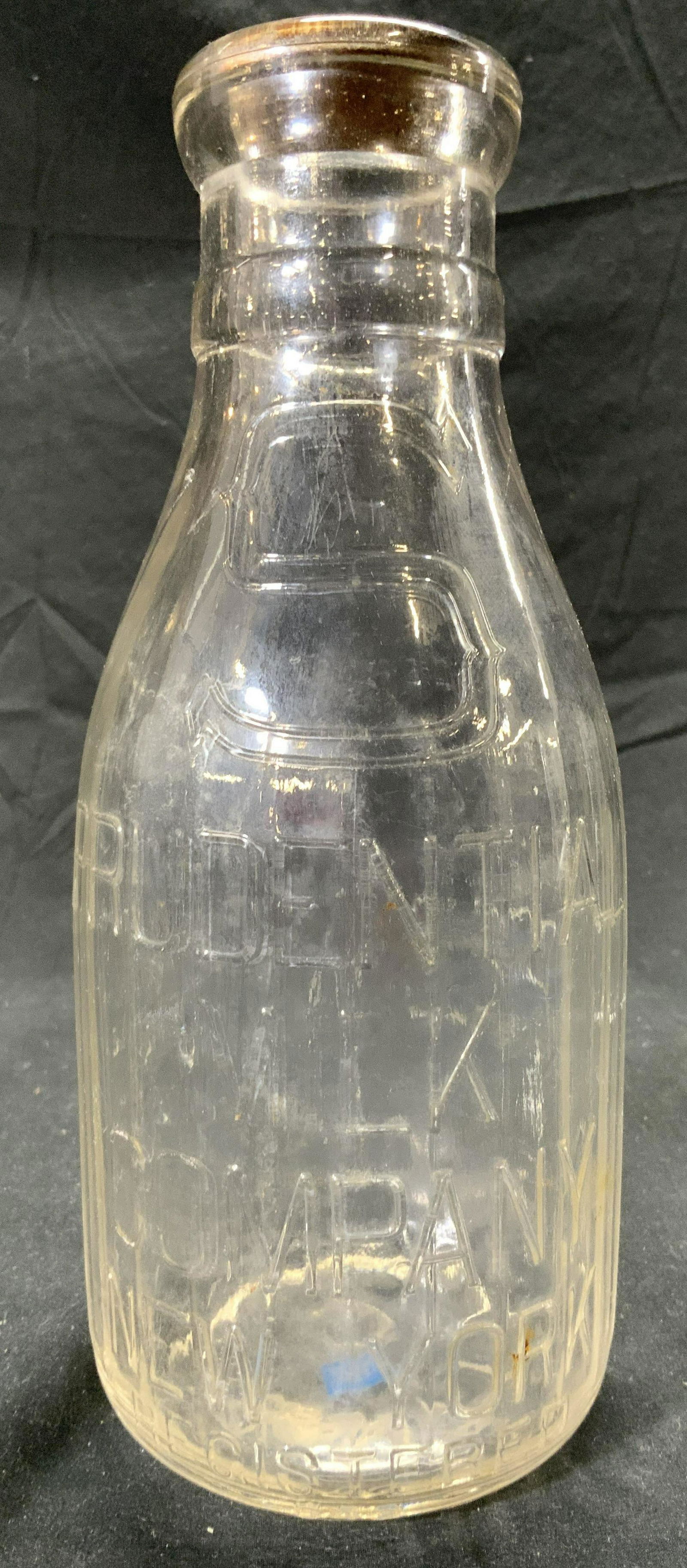 Vntg PRUDENTIAL MILK Co Glass Milk Bottle: Vintage, possibly antique, PRUDENTIAL MILK COMPANY glass milk bottle. Bottle measures approx. 4 x 9.5 inches. Some surface wear consistent with exposure. Property of Manhattan New York City Americana,