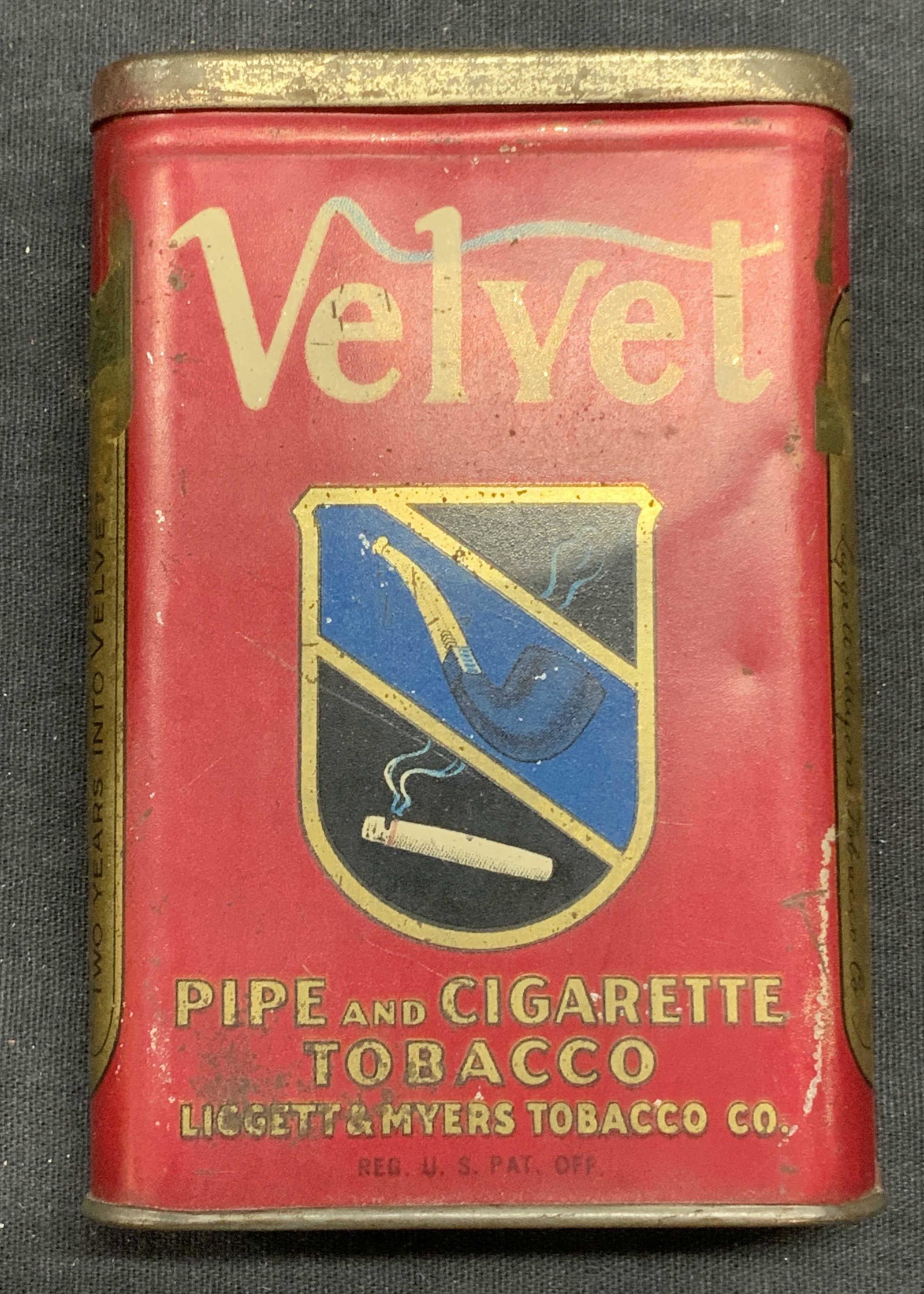 Antique Velvet Pipe & Cigarette Tobacco Tin USA: Antique 1910 Liggett and Myers Tobacco Co. Velvet pipe and cigarette tobacco tin. Made in USA. Surface wear consistent with exposure. Measures approx. 3 x 7/8 x 4 3/8 inches. Partial tax stamp reads 1