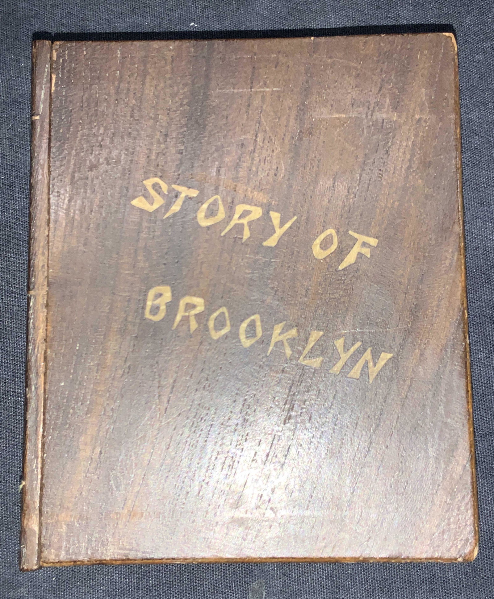 Story Of Brooklyn Wooden Puzzle Box, Japan: Wooden puzzle box with Story of Brooklyn carved into the front. Marked Nippon on backside Moderate wearing to edges of box. Puzzle box works by pushing the spine down and sliding the front cover forwa