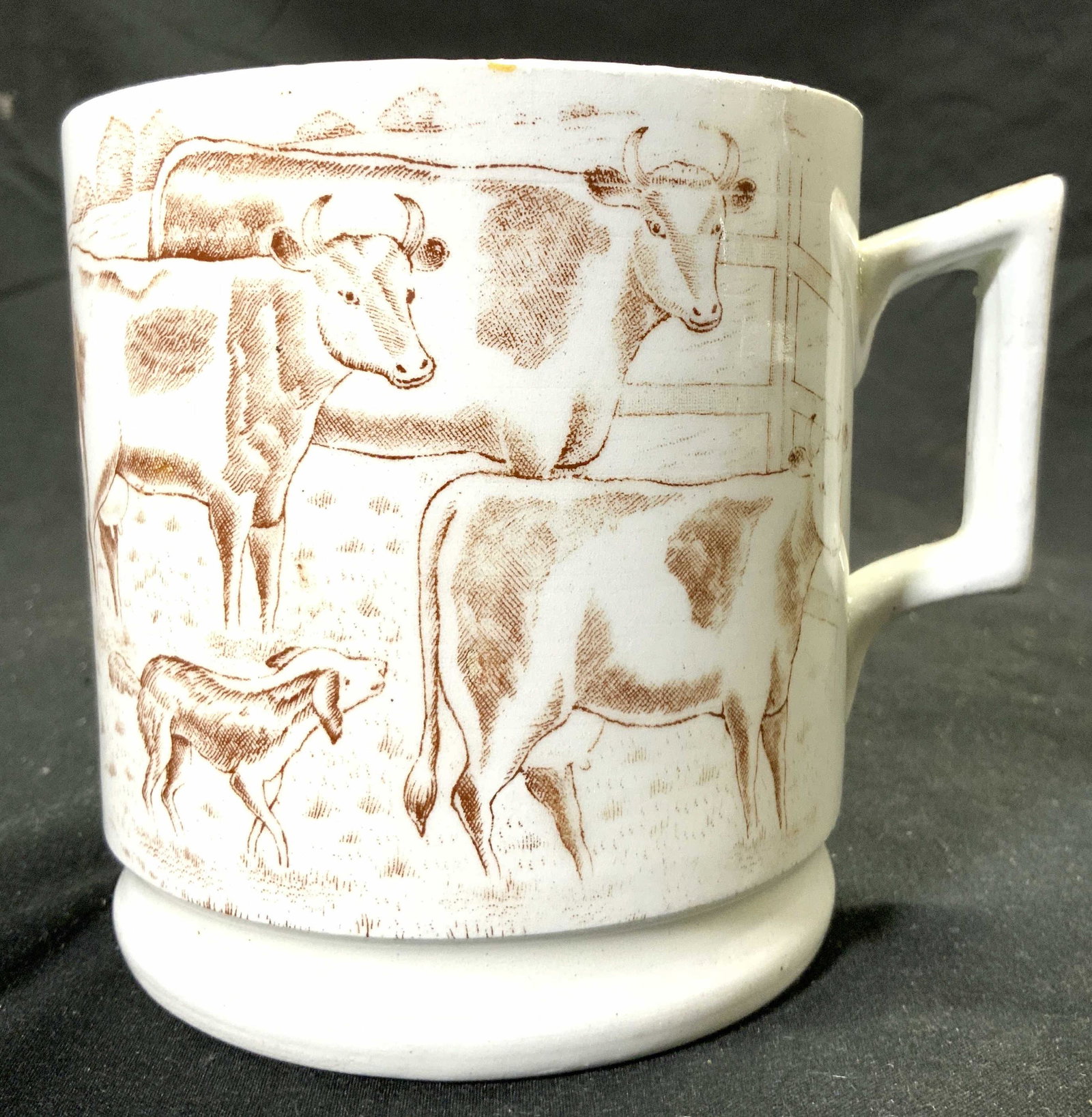 Trademarked Porcelain Mug Vessel W Cow Detail: Underside is trademarked illegibly. Piece is white toned & porcelain with brown toned etched cow detailing. Mug measures approx 4 inches tall 3.75 inches wide 5 inches deep. Mug, porcelain mug, tradem
