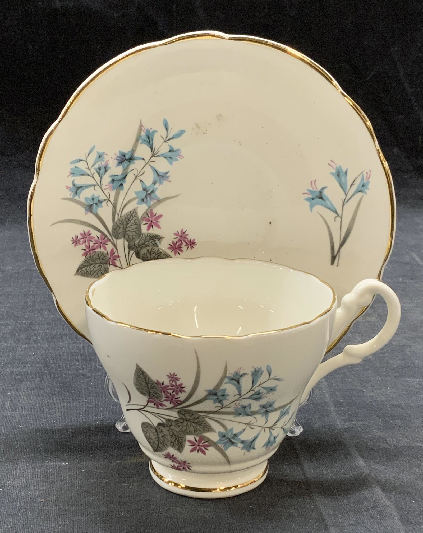Regency Bone China Floral Teacup & Saucer: Regency bone china teacup and saucer with floral motif. Trademarked to underside.s made in England. Some surface wear to each piece consistent with exposure. Sauce measures approx. 5.5 inches wide. Te