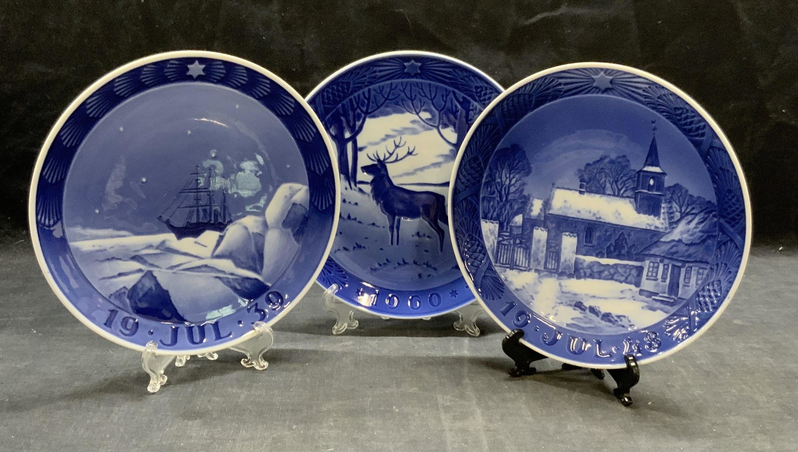 3 Vintage Royal Copenhagen Porcel Christmas Plates: Set of 3 vintage Royal Copenhagen porcelain Christmas plates in blue. All pieces trademarked to undersides. Dates include 1939 (ship motif), 1948 (church motif), and 1960 (The Stag). All pieces in goo