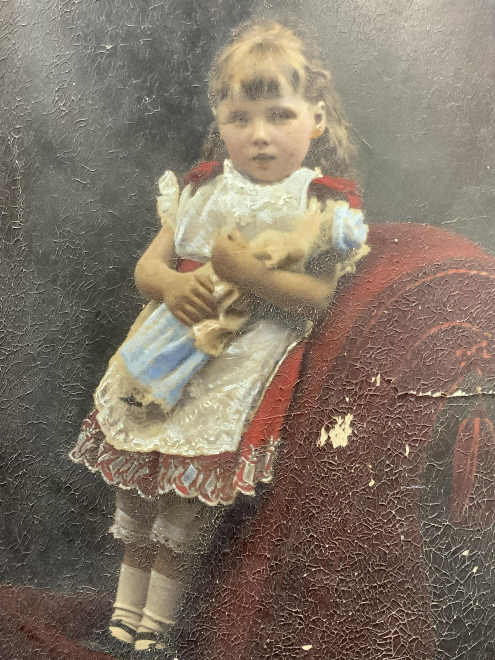 Vintage Hand Colored Child Portrait Photo: Vintage, possibly antique. Photograph of a young girl holding a doll with hand painted elements, such as her dress and dolls dress. No frame. Approximately 13 x 10 inches Evident warping and tearing a