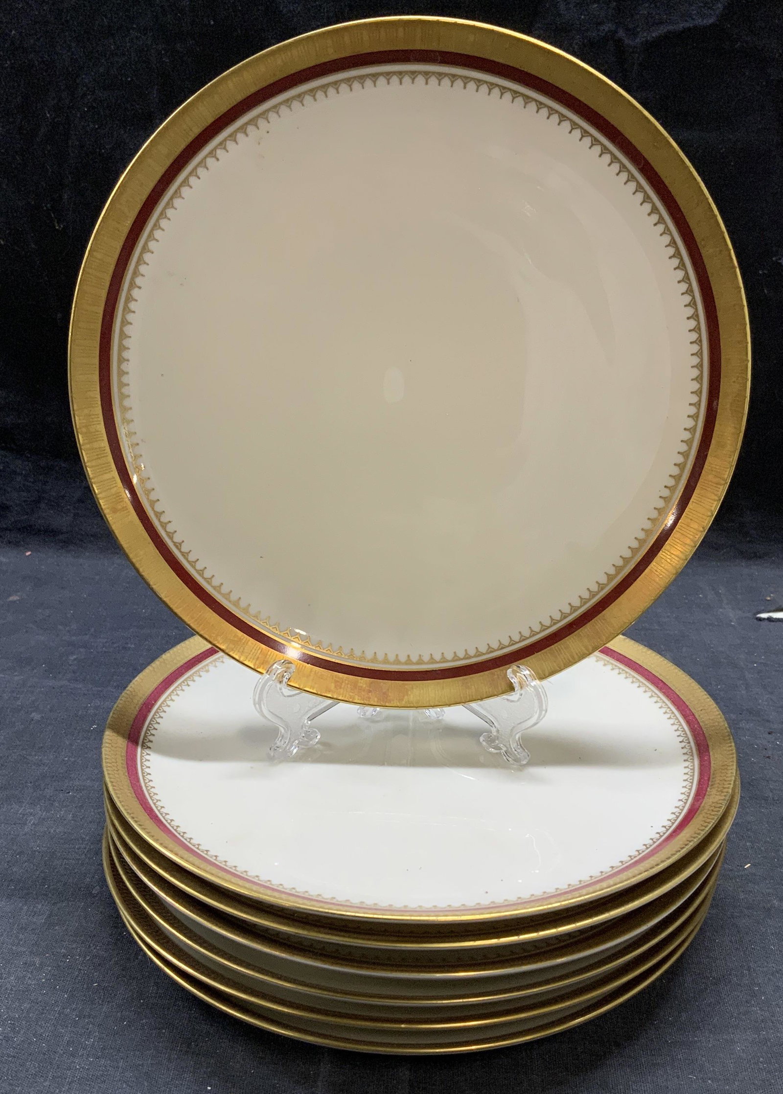 Set 7 Eschenbach Gilt Porcelain Plates, Germany: Set of 7 Eschenbach porcelain plates with burgundy and gilt decorated borders. Two different patterns. 3 plates with single border, 4 plates with triple border. All pieces trademarked to underside. Al