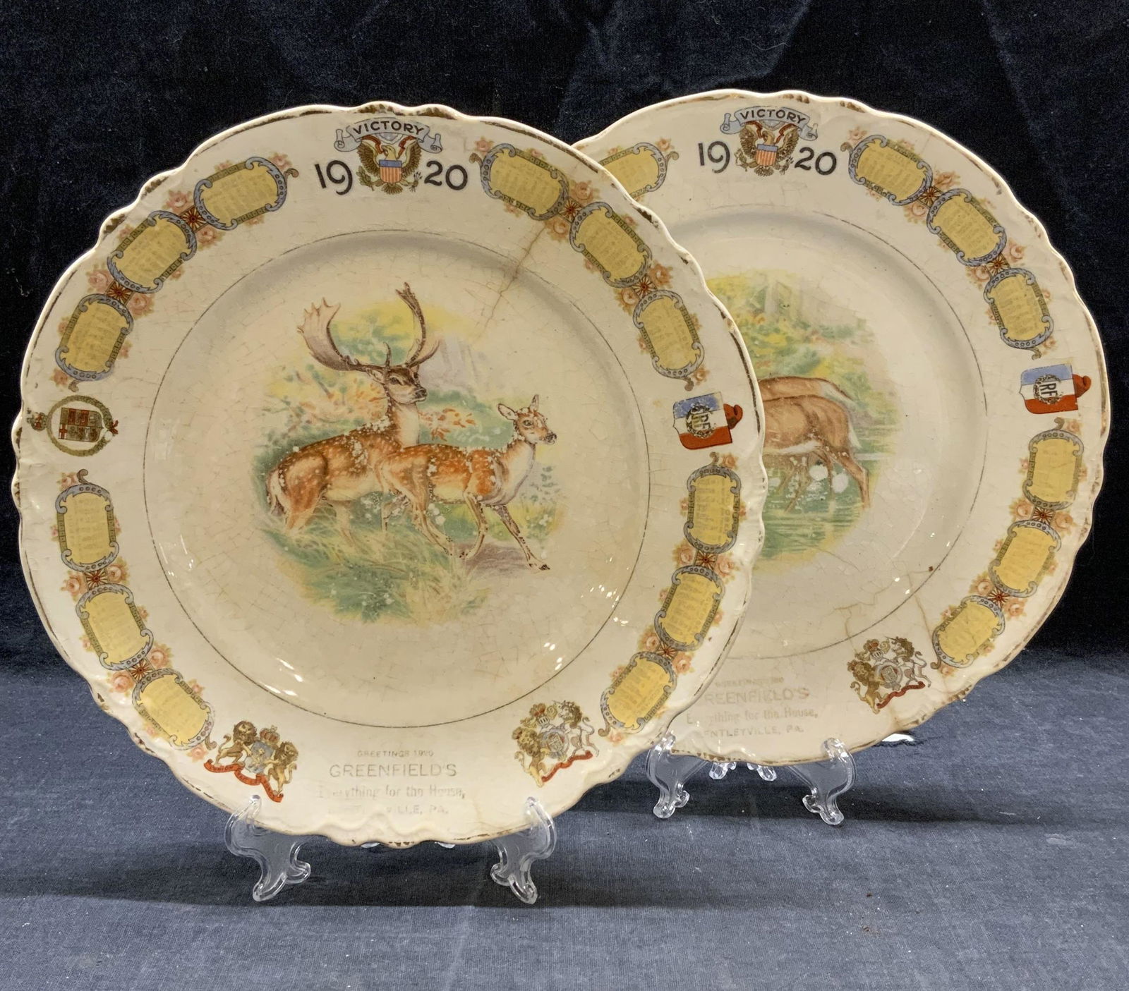 Pair KT&K China Victory 1920 Calendar Stag Plates: Pair of antique KT&K china Victory 1920 calendar plates with stag motifs. Surface wear to each consistent with exposure. Hairline cracks and crazing observed to each piece. Measure approx. 9 inches di