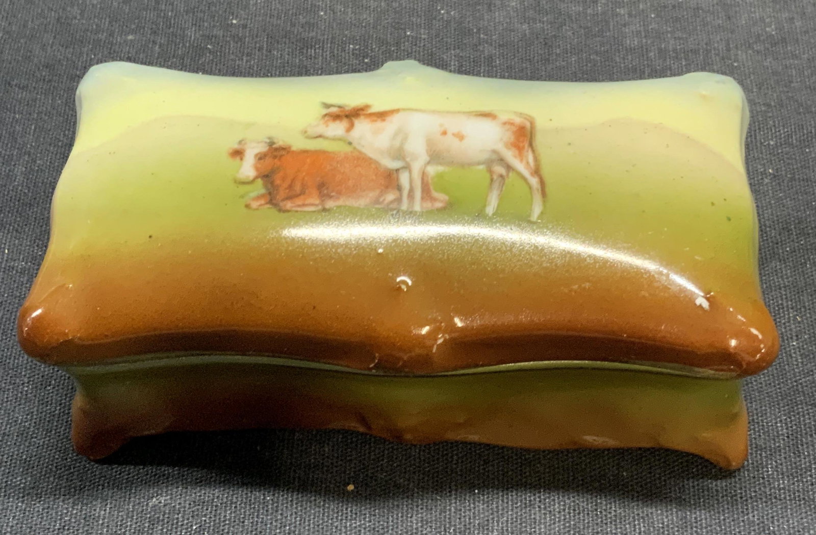 Antique Royal Bayreuth Porc Cow Pill Box Germany: Antique Royal Bayreuth porcelain pill box with cow motif. Trademarked to underside, made in Germany. Some surface wear consistent with exposure. Measures approx. 3.5 x 1.5 x 1 inches. Property of Manh