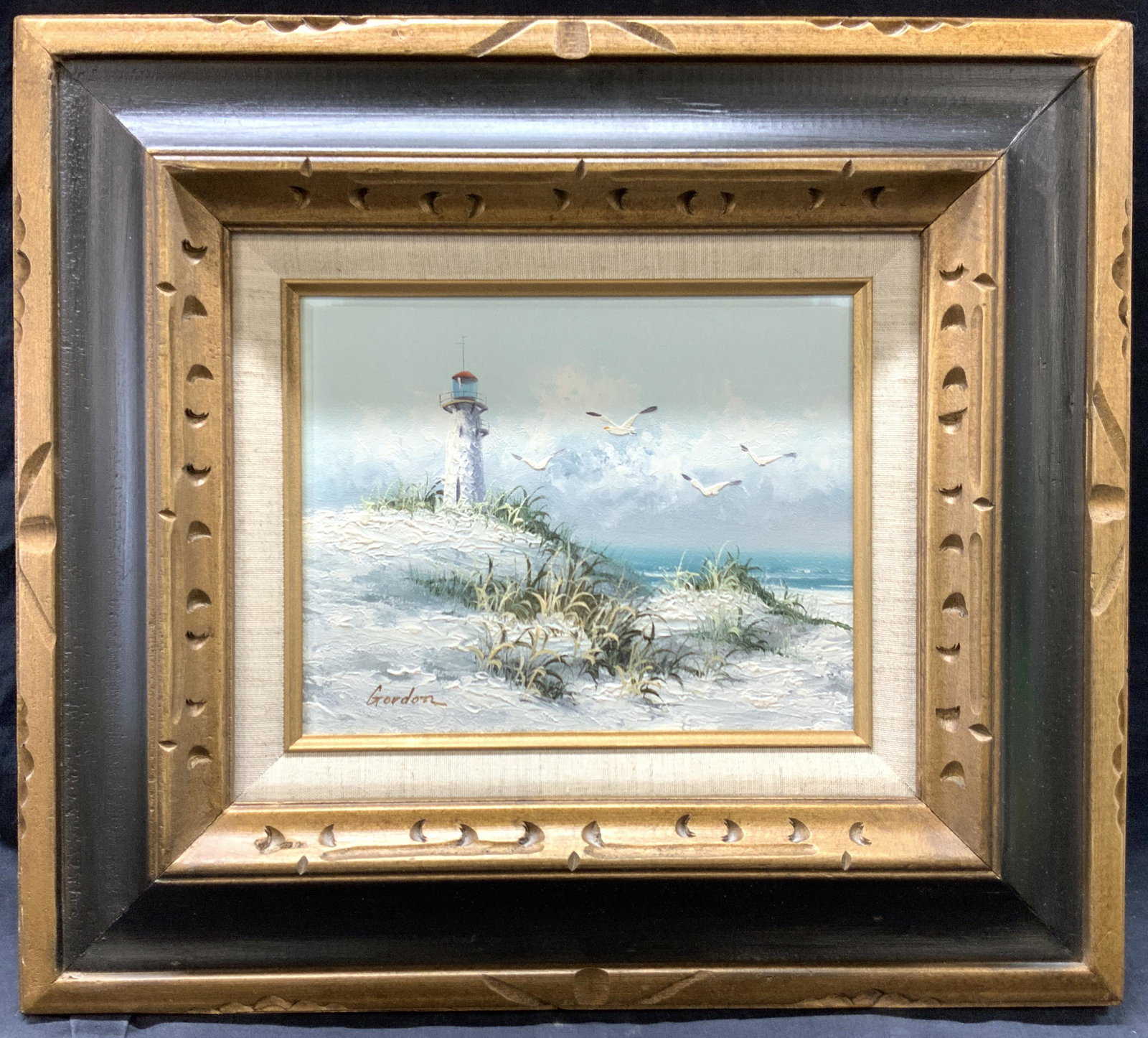 Gordon Signed Sea Side Landscape Oil Painting: Signed on lower left corner Gordon Depicts a seaside landscape with white lighthouse on a cliff edge, Framed in carved wooden frame with gold painted edges. Approximately 16.75 x 18.75 inches window m