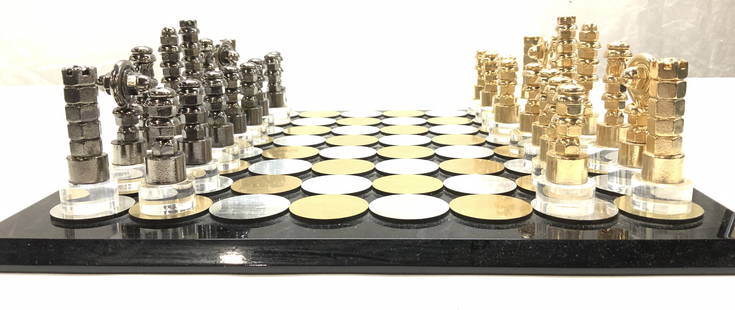 Lucite & Metal Chess Board and Chess Pieces: Black lucite chess Bros with raided polka dot piece holder in gold tone and silver tone metal. Board measures 14 x 14 in. Players pieces are held in a lucite carry box with handle. These are gold tone