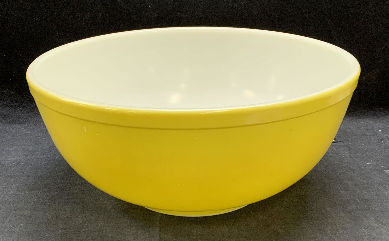 Pyrex Yellow Glass Mixing Bowl: Pyrex yellow glass mixing bowl. Trademarked to underside. Measures approx. 10.5 x 4.5 inches. Some surface wear consistent with exposure. Pyrex, Pyrex bowl, Pyrex mixing bowl, yellow bowl, mixing bowl
