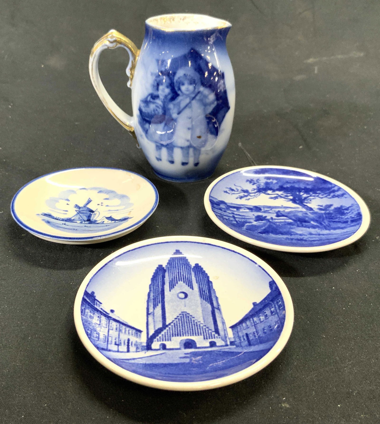Lot 4 Vintage Blue and White Porcelain Accessories: Lot includes 3 saucers/plates & 1 pitcher. Underside of 2 dishes are marked ROYAL COPPENHAGEN PAJANCE, one GRUNDTVIGS KIRKEM, One DANSK LANDSKAB. One marked ZENITH MADE IN HOLLAND. Pitcher has gilt ha