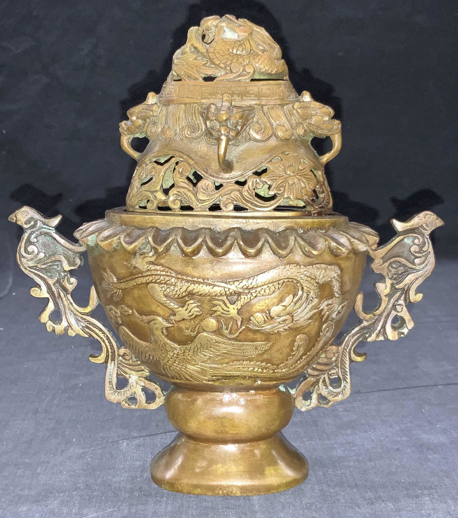 Stamped Brass Dragon Motif Asian Incenser: Stamped on underside. Patina Brass made incenser with dragon motifs throughout and cut outs on top lid. Side handles that resemble birds. Approximately 7.25 inches tall and 7 inches wide. Evident wear