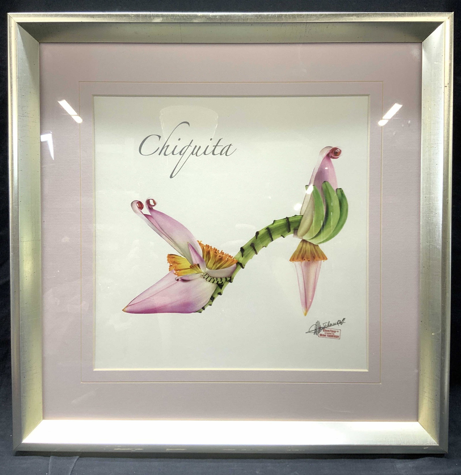 Michel Tcherevkoff Shoefleur Chiquita Litho: Marked on lower right corner shoe Fleur created by Michel Tcherevkoff Depicts a high heel show made of various flowers with the word Chiquita over it. Framed in silver metal leafed wooden frame and pi