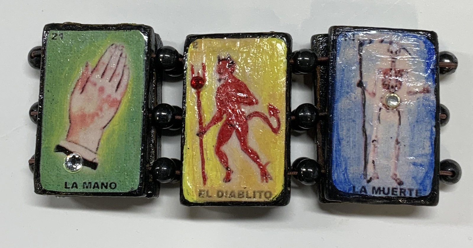 Mexican Folk Art Spiritual Pendant Bracelet: Mexican folk art spiritual beaded pendant stretch bracelet with wooden lacquered pendants and composite beads. Some surface wear consistent with exposure. Bracelet has some stretch. Measures approx. 2