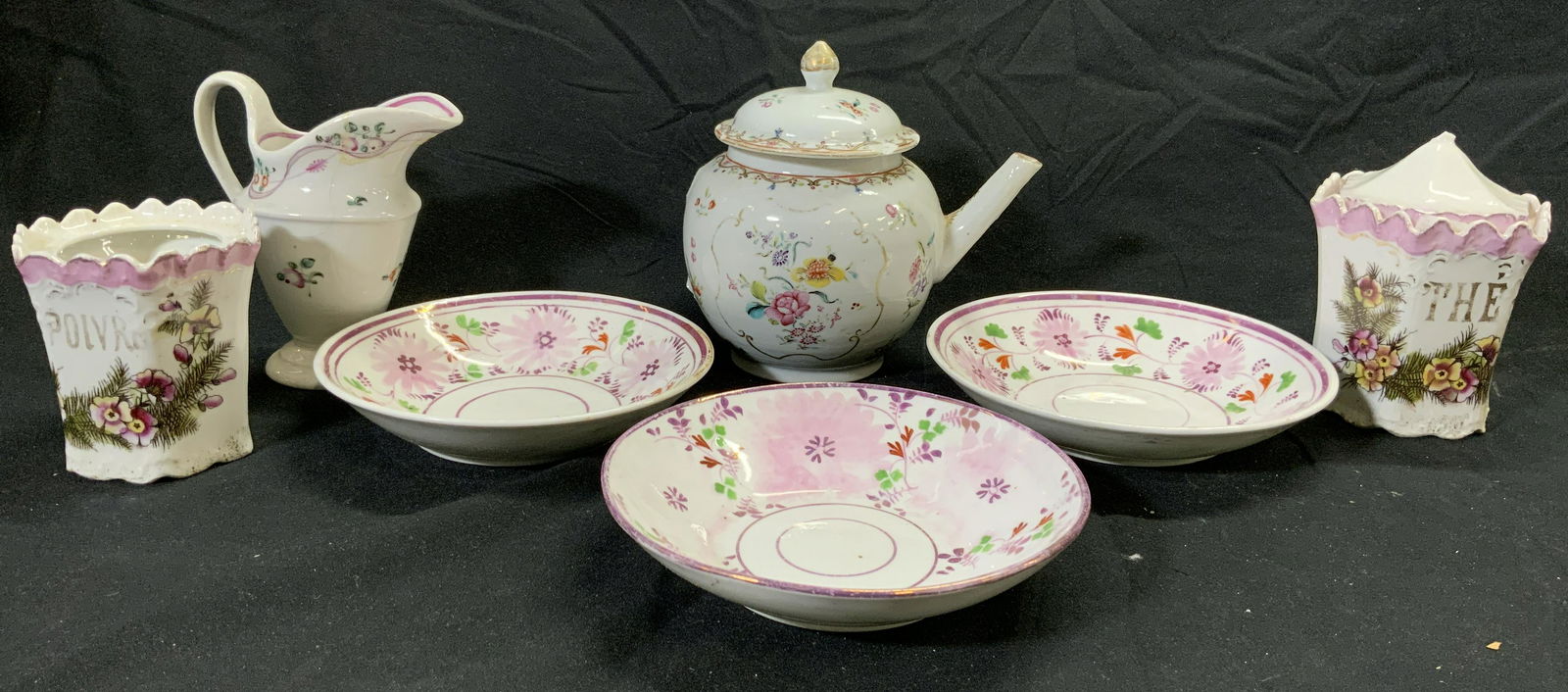 Lot 7 Vintage Assorted Porcelainware: Lot includes 3 saucers, 1 lidded teapot, 1 creamer dish, 2 sugar dishes (1 with lid). Each piece has floral & leaf detail. Teapot measures approx 5.5 inches tall 4.25 inches wide 5.5 inches deep. Porc