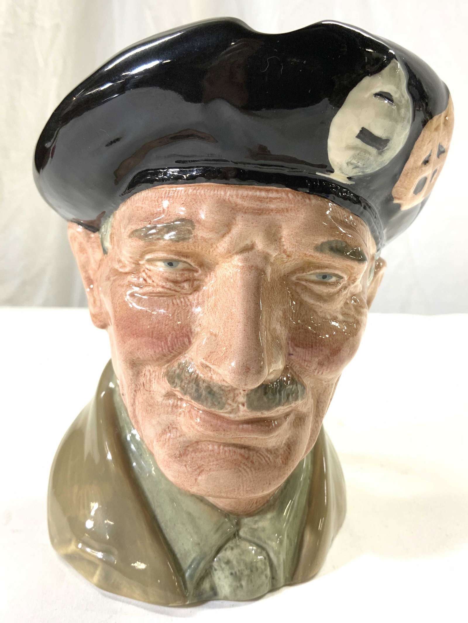 ROYAL DOULTON MONTY Porcelain Mug ENGLAND: Underside is marked ROYAL DOULTON MONTY MADE IN ENGLAND. Mug appears to be vintage. Depicts an elderly male face figure wearing hat. Piece measures approx 6 inches tall 6.25 inches deep 7 inches wide.