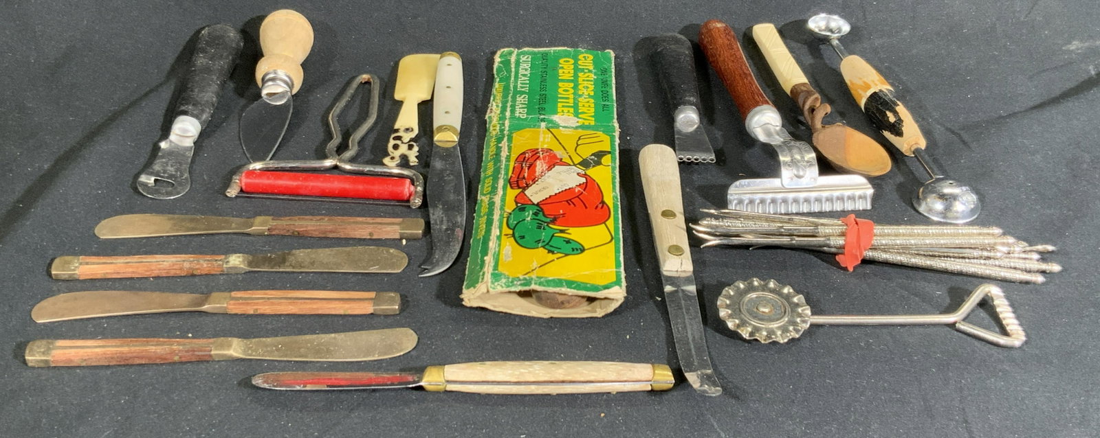 Lot 18 Vintage Kitchenware Utensils & Accessories: A group lot of vintage kitchenware utensils & accessories. Lot includes knives, picks, spreaders, and more. Pieces are crafted from metal, wood, bone, and composite materials. Multi Purpose Four in On