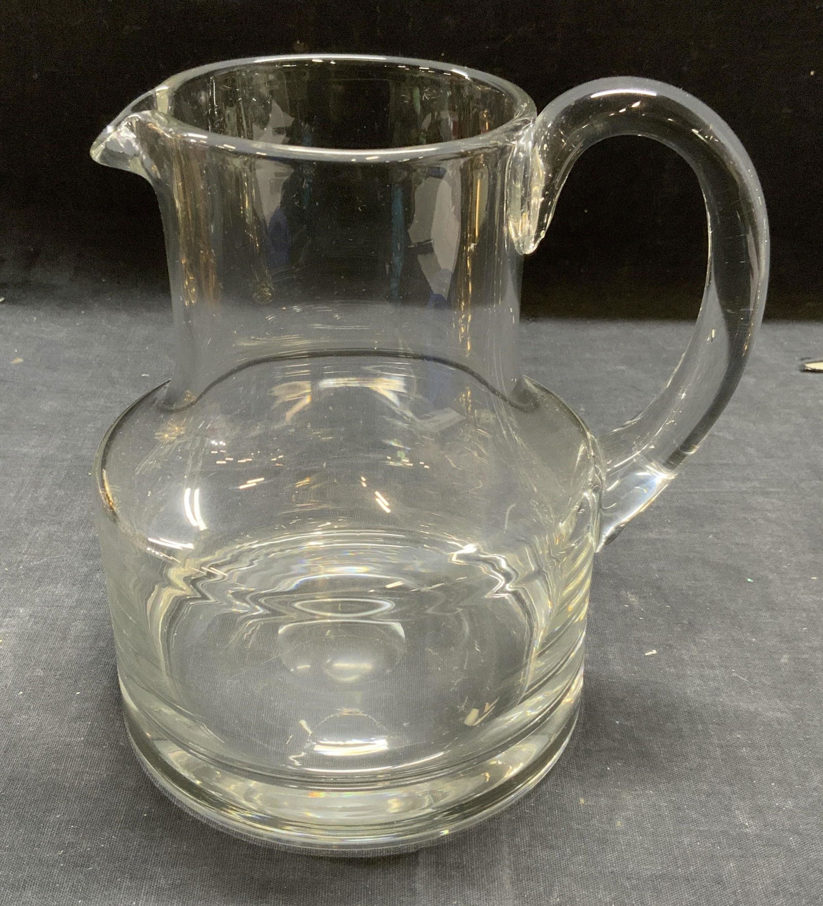 Transparent Glass Pitcher: Transparent thick walled glass pitcher. Some surface wear consistent with exposure. Measures approx. 7 x 5.25 x 6.75 inches. Pitcher, glass pitcher, tableware, table accessories, kitchenware, kitchen