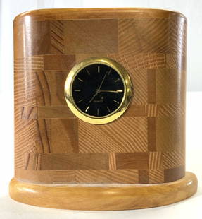 WOODSMITHS Standing Wooden Desk Clock: Underside reads WOODSMITHS CAPE BRETON N.S. Clock is tan toned & appears to be wooden. Clock face is black with gold toned hands and tic marks. Piece measures the 4 inches tall, 4.5 inches wide 1.5 in