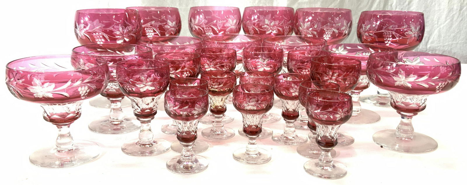 Hand Blown Cranberry Crystal Stemware, 27: Luxury Bohemian Crystal Stemware, Cranberry with clear cut outs of grape vine and grape bunches. Hand Formed vintage Crystal goblets with faceted stem. Set 6 larger stemware ; 5.5 x 4 in. 1 base chip