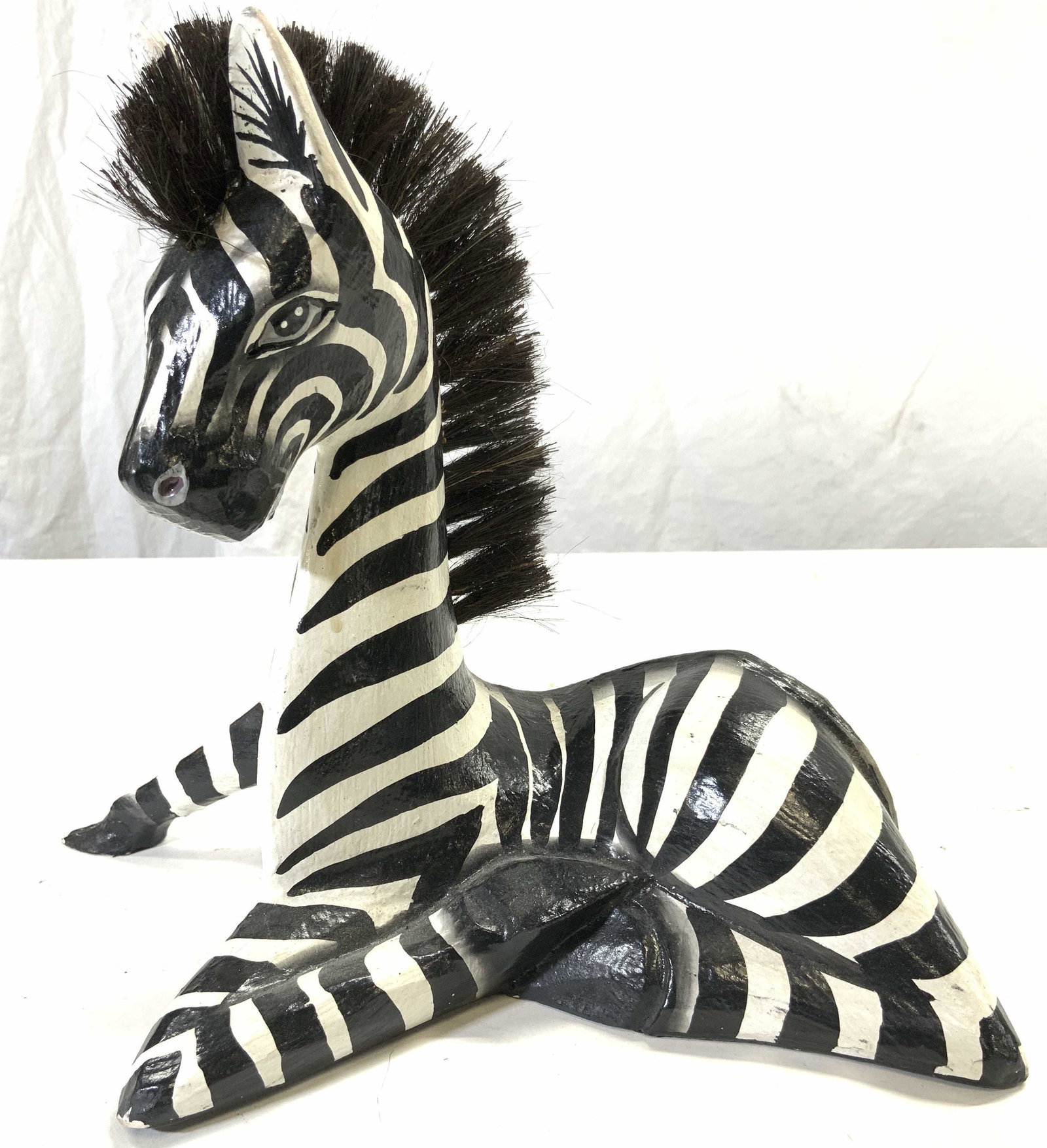 Hand Crafted Wooden Zebra Figure: Piece is wooden, appears to be hand crafted. Figure depicts a kneeling zebra with one hoof out. Piece measures approx 10inches tall 6 inches wide 12 inches deep. Wooden zebra, zebra figure, hand craft