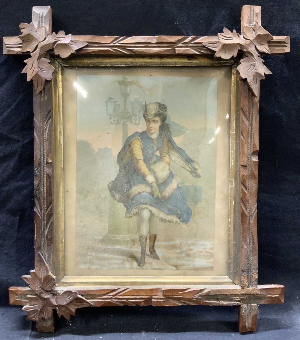Vintage Figural Litho W Ornate Wooden Frame: Vintage litho depicting a woman in blue furs outside with a carriage and lamp post in the distance. Framed in carved wooden frame with leaf accents affixed to the corners. Approximately 14 x 13 inches