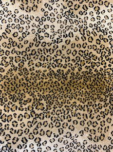 Leopard Print Wool Area Rug: Rug has tan & black toned leopard print detail. Edge of rug is black toned. Rug measures approx 72 inches long 35 inches wide. Rug, leopard print rug, area rug, wool rug, carpet, home decor, homewares