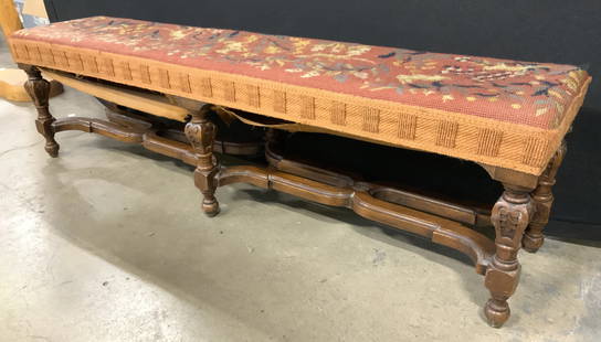 Antique Low Wooden Needlepoint Bench: Bench has carved wooden frame. Piece has intricate multi toned floral & leaf detailed upholstery. Bench has 6 carved wooden legs. Piece measures approx 41 inches long 11 inches tall 9.5 inches deep. B