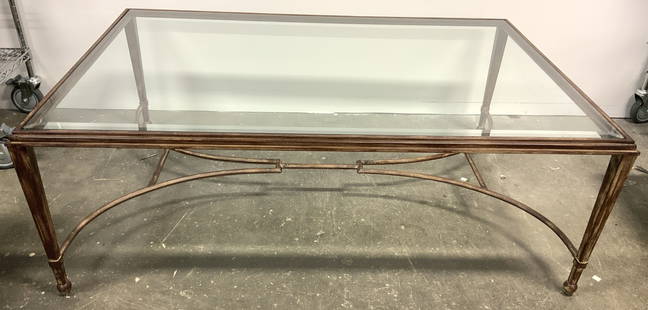 Iron Base Glass Top Coffee Table: Coffee table has iron base/frame. Piece has beveled glass top. Legs have double arch stretcher in between legs. Legs taper inward towards bottom. Measures approx 54 inches long 36 inches deep 19 inche