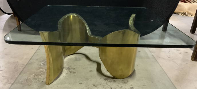 SILAS SEANDEL Signed Glass Top Sculptural CF Table: Base is signed SILAS SEANDEL. Piece has gold toned brass sculptural base w S shape structure. Table has rounded square shaped thick glass top approx .85 - 1 inch thick. Coffee table measures approxima